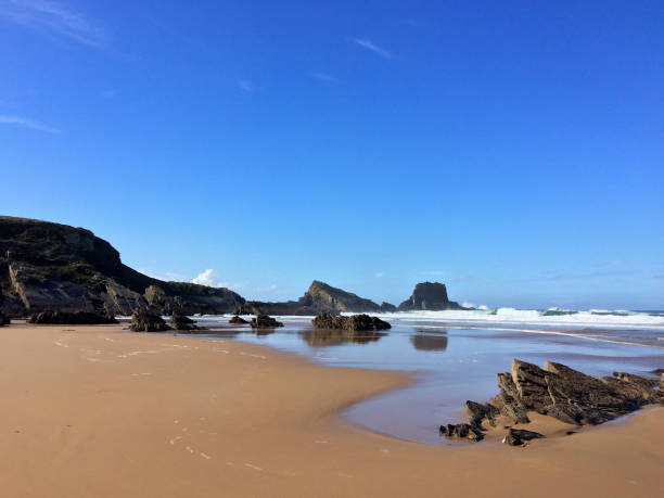 istock rocks on the ocean, seascape, beautiful sandy beach, clear blue sky 1081672598