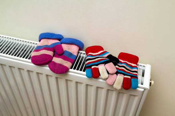 istock Children's warm hand knitted striped woolen gloves drying on hea 1081672790