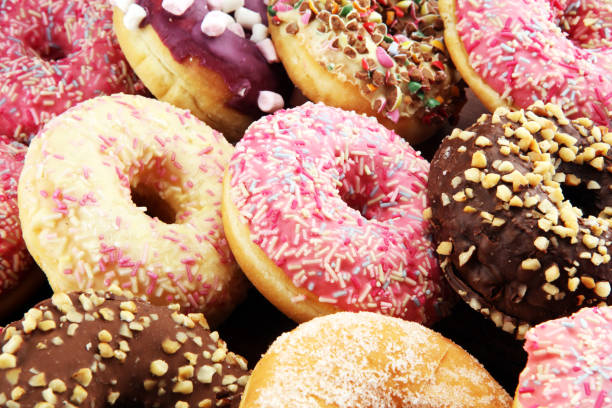 istock assorted donuts with chocolate frosted, pink glazed and sprinkles donuts 1081674604