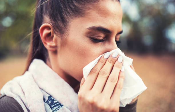 istock Cold and flu. Woman blowing her nose with a tissue 1081675164