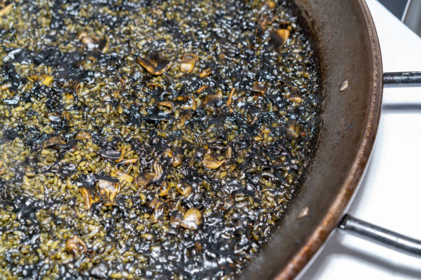 From above shot of rusty metal pan of delicious Spanish rice with squid