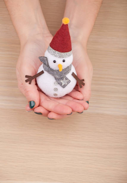 istock textile snowman woman hands wooden table studio 1081679770