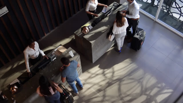 High angle view of couples checking into hotel at the front desk