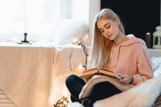 istock Pretty girl Imagining the book extraordinary world while lying i 1081686052