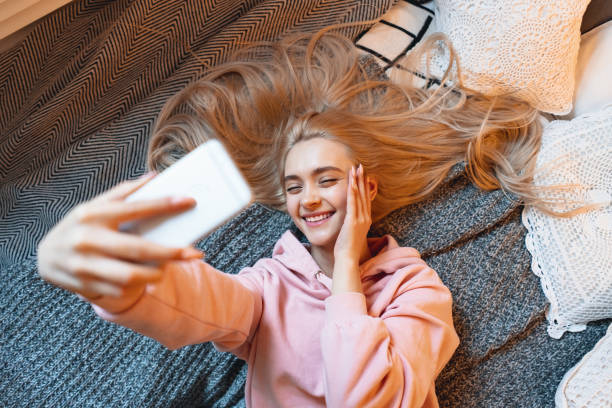 istock Pretty young girl having fun, making selfie with smart phone whi 1081686146