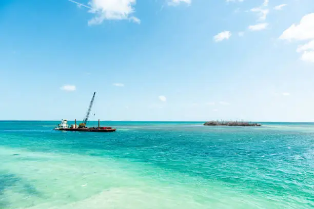 Marathon, USA Florida construction site crane building on island with colorful vibrant turquoise sunny water on gulf of mexico, landscape