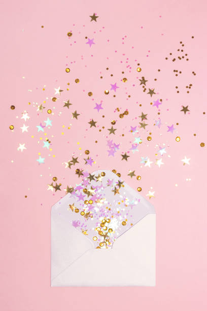 Golden and pink confetti scattered from envelope on pastel pink background. Golden and pink confetti pouring out of white envelope on pastel pink background. View from above. Flat lay. Holiday, congratulations or good news concept. pink envelope stock pictures, royalty-free photos & images