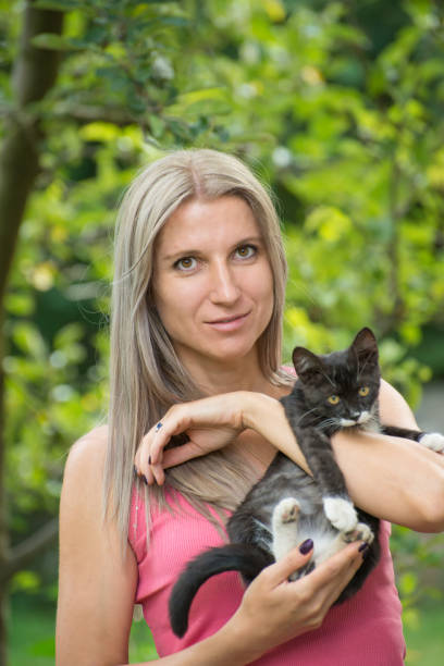 istock Girl holding a black cat with a blurred background 1081691720