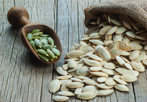 Pumpkin seeds on wooden vintage rustic backdrop. Composition of pumpkin seed. Great for healthy and dietary nutrition. Concept of nuts. stock photo