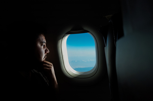 Businessman looking through the airplane window