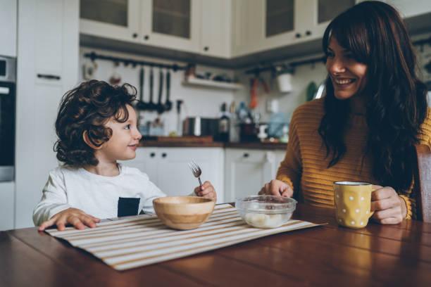 mały chłopiec i mama na stole - baby eating child mother zdjęcia i obrazy z banku zdjęć