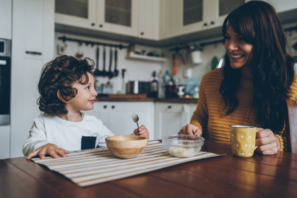 little boy and mom on the table - breakfast family child healthy eating imagens e fotografias de stock