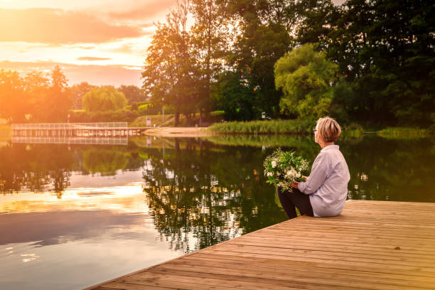 istock Sad lonely beautiful woman sitting on the pier. 1081706006