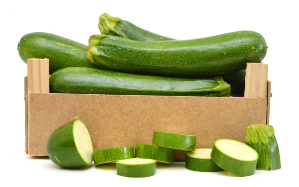 istock fresh zucchini's (Cucurbita pepo) in a wooden crate on a white background 1081707520