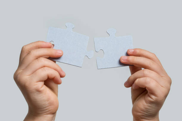 istock Two Puzzle Pieces Coming Together isolated on gray background 1081708570