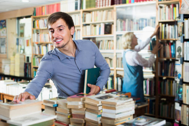 istock Young smiling male customer holding new book 1081719246