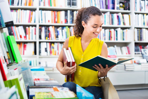 istock Woman standing with open in publishers store 1081719318