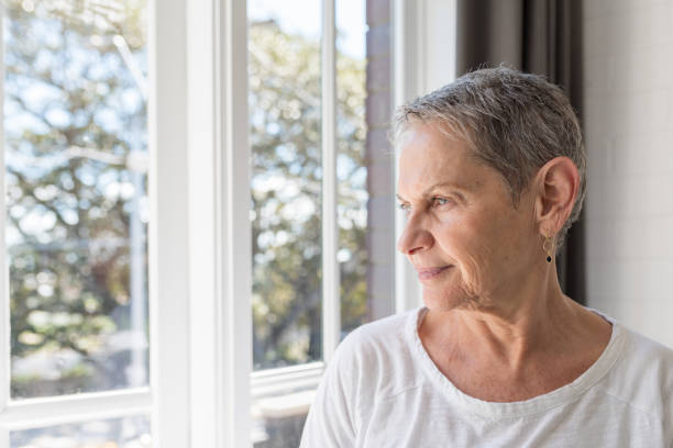 istock Senior Woman Looking Through Window At Home 1081728448