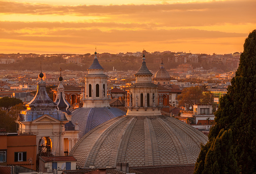 View of Rome historic center skyline with baroque domes and bell towers at sunset