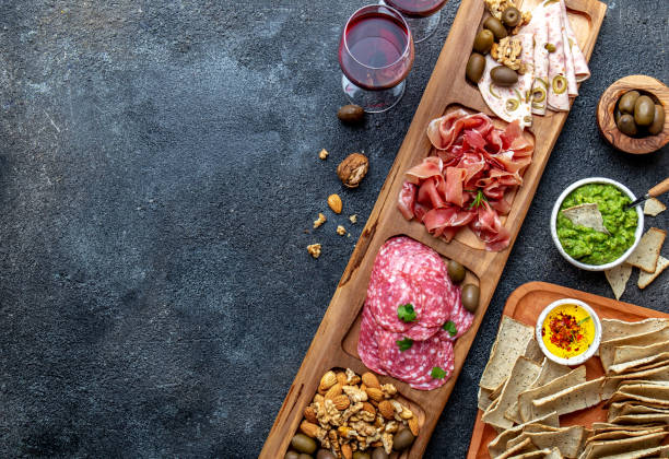 antipasto platter. ham serrano, salami olive jamon dip sauces and red wine - italian appetizer imagens e fotografias de stock