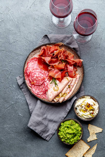 istock Antipasto. Meat platter, chips and sauces, red wine on gray background. Top view 1081735744