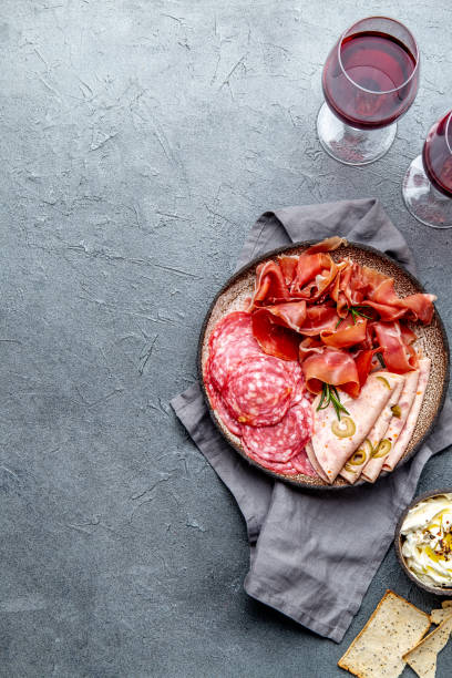 istock Antipasto. Meat platter, chips and sauces, red wine on gray background. Top view 1081735762