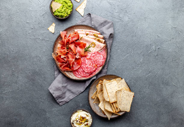 istock Antipasto. Meat platter, chips and sauces, red wine on gray background. Top view 1081735764