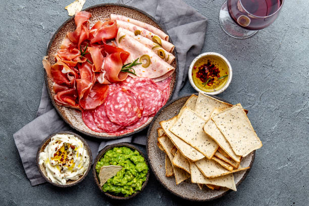 istock Antipasto. Meat platter, chips and sauces, red wine on gray background. Top view 1081735798