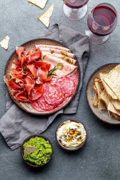 istock Antipasto. Meat platter, chips and sauces, red wine on gray background. Top view 1081735810