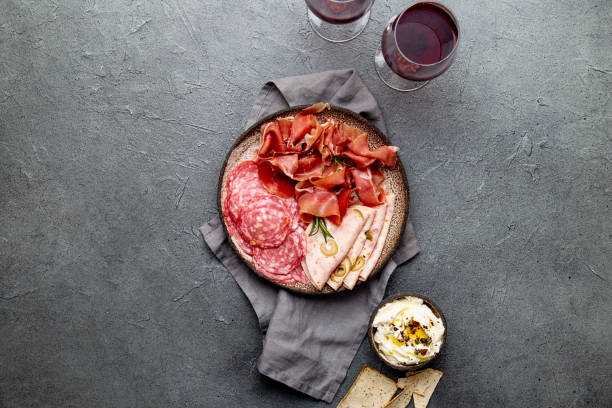 istock Antipasto. Meat platter, chips and sauces, red wine on gray background. Top view 1081735904