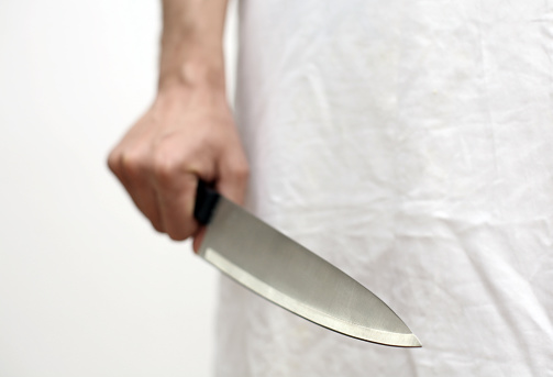 hand of a butcher holding a sharp knife