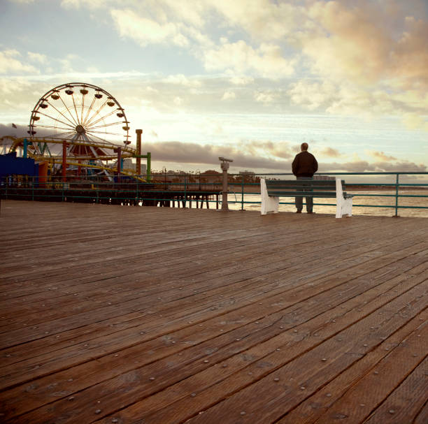 Man Standing Alone on Santa Monica Pier at Sunset stock photo