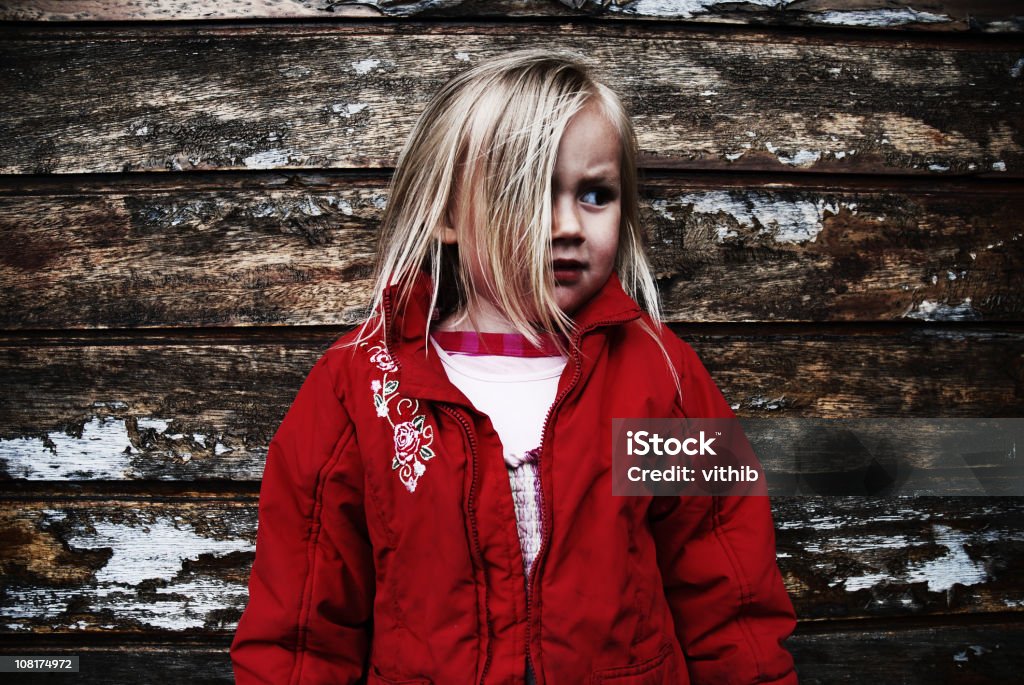 Девочка Смотреть Обеспокоенный стоя перед старой стеной - Стоковые фото Страх роялти-фри