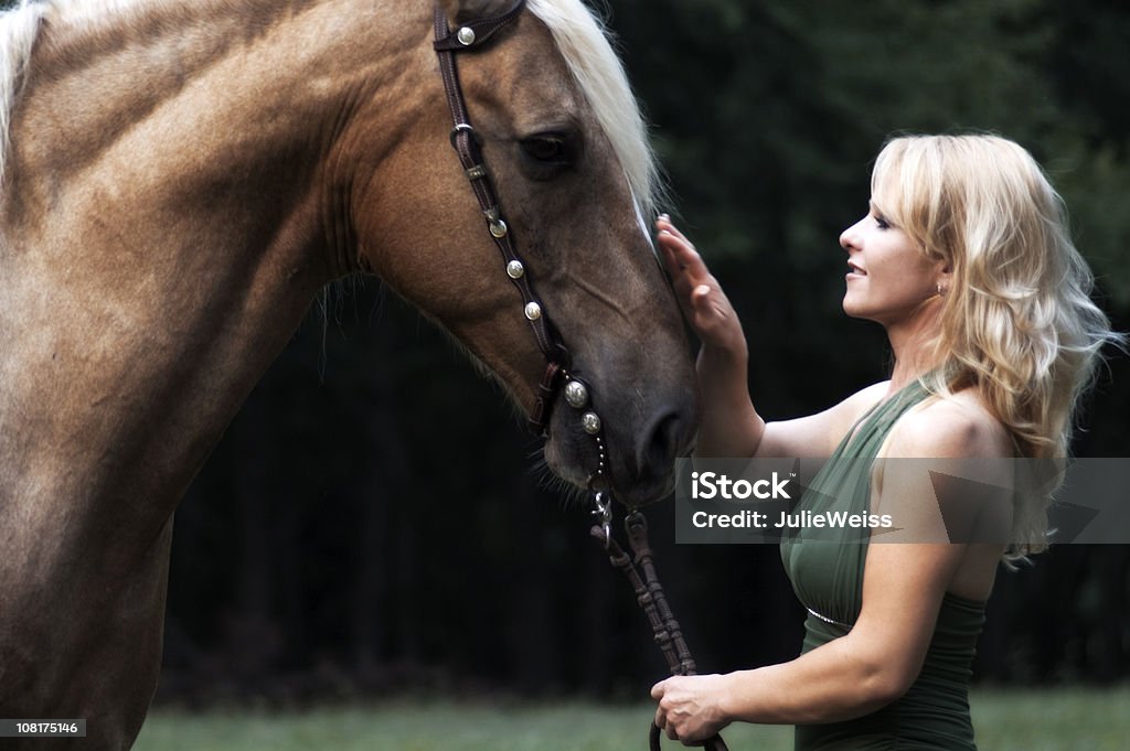 Belle Blonde avec un cheval - Photo de Cheval libre de droits