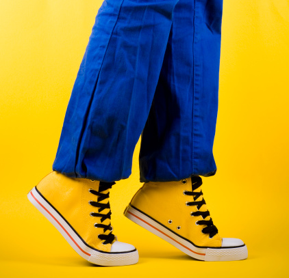 Close up of faded blue jeans pants, with floor in the background, stock photo.