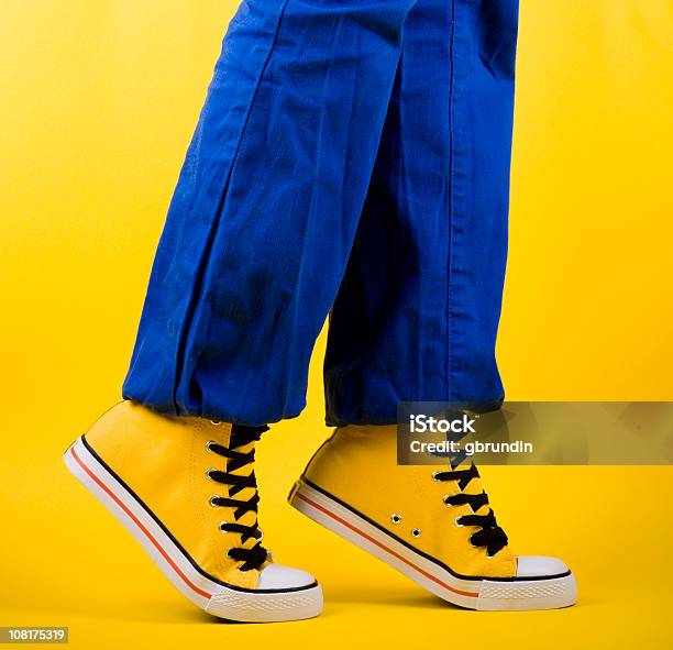 Person In Yellow Shoes Standing On Toes Stock Photo - Download Image Now - Balance, Blue, Canvas Shoe