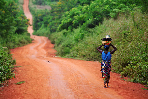 femme d'afrique sur la route - porter sur la tête photos et images de collection