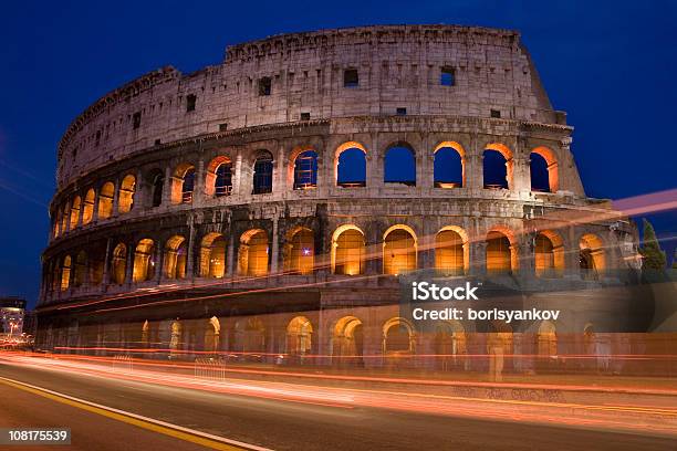 Carros De Condução Por Coliseu Em Roma À Noite - Fotografias de stock e mais imagens de Anfiteatro - Anfiteatro, Anoitecer, Antigo