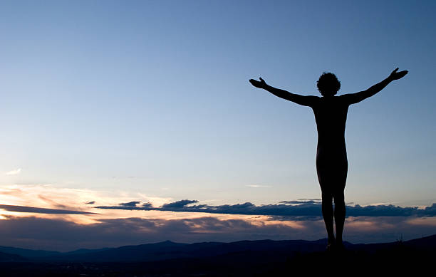 silhueta de homem com braços abertos para o céu ao pôr do sol - yoga nudist silhouette naked imagens e fotografias de stock