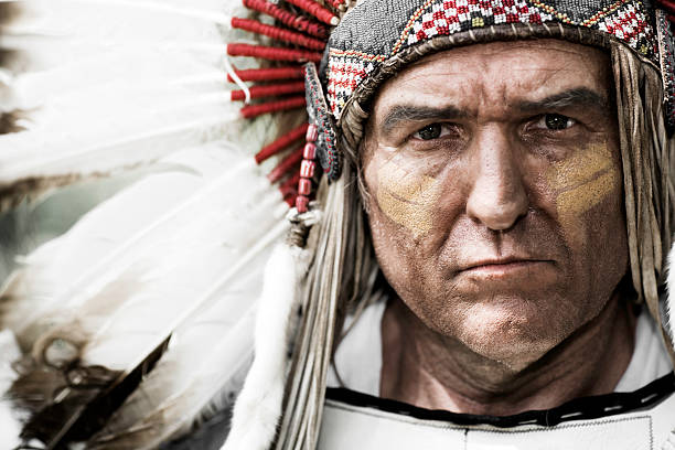 Native American Chief Horizontal portrait of a Native American Chief wearing a feathered head dress. headdress stock pictures, royalty-free photos & images