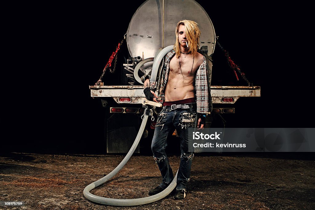 Punk Male Holding Old Water Hose From a Truck  Truck Driver Stock Photo