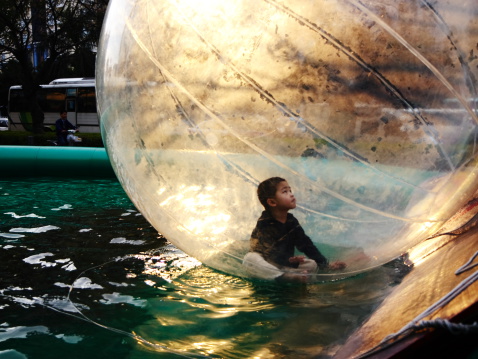 Closeup image of a white plastic ball placed on the edge of a pool in a public water park, Chiang Mai, Thailand.