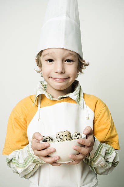 istock Little Boy Chef Holding Bowl of Eggs 108175905