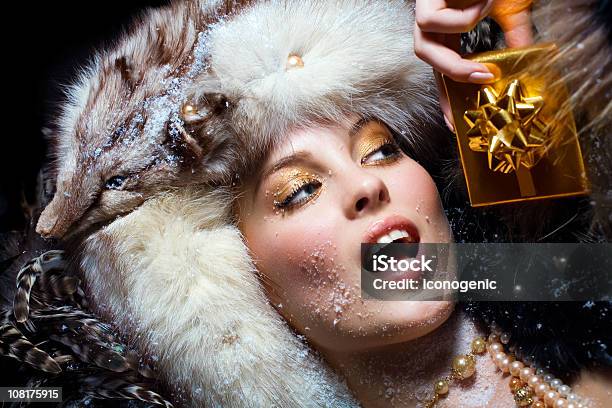 Foto de Mulher Vestindo Chapéu De Pele E Segurando A Caixa De Presente e mais fotos de stock de Luxo