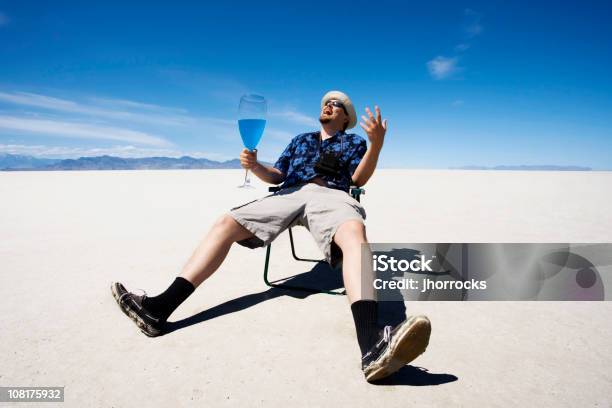 Foto de Homem Sentado Na Cadeira E Beber No Salt Flats e mais fotos de stock de Azul - Azul, Vitalidade, Adulto