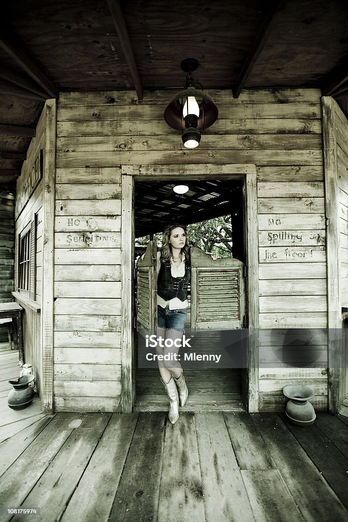 Joven mujer caminando a través de puertas Saloon - Foto de stock de Taberna norteamericana libre de derechos