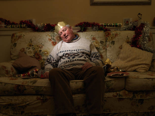 istock Man Wearing Christmas Hat, Sleeping on couch 108176031