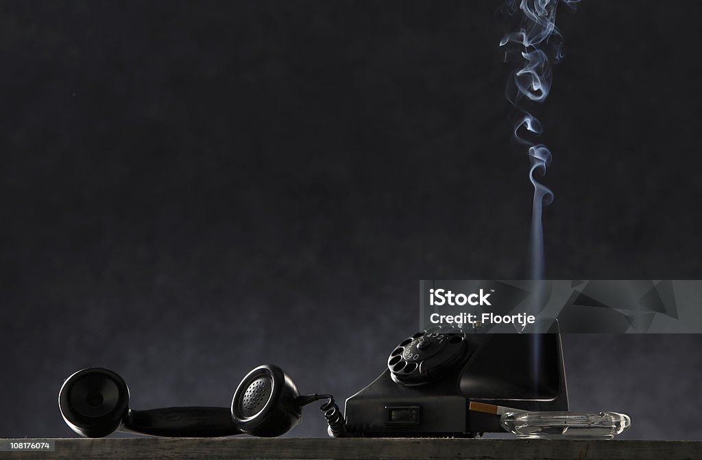Schwarz: Vintage Telefon und Zigarette in Aschenbecher auf dem Tisch - Lizenzfrei Aschenbecher Stock-Foto