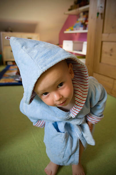 istock Little Boy Wearing Hooded Bathrobe Looking Curious 108176077