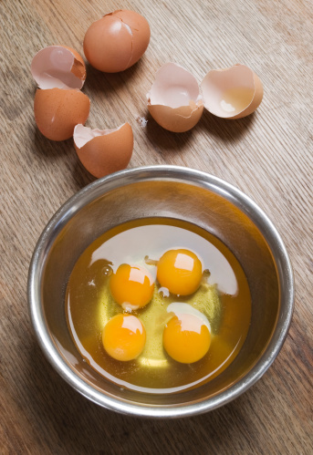 Four cracked eggs in a metal bowl on a rustic wooden table top.\nTo see more of my food related images, click on the banner.\n[url=http://www.istockphoto.com/file_search.php?action=file&lightboxID=6016700][img]http://stuartpitkin.co.uk/istockfood.jpg[/img][/url]